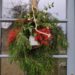 Décoration de Noël sur porte de la maison faite de sapin, corde et cloche